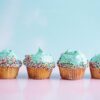 six teal icing cupcakes with sprinkles