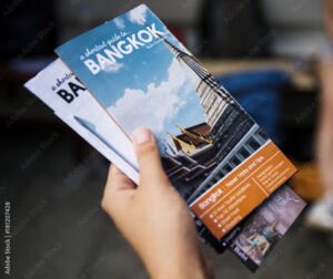 Closeup of hand holding Bangkok travel guide brochure