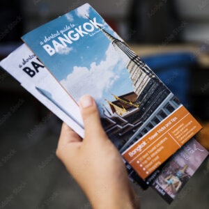 Closeup of hand holding Bangkok travel guide brochure